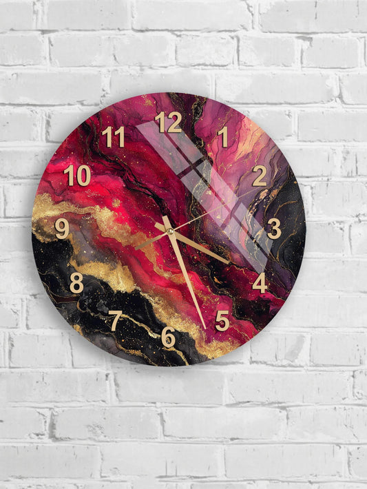 A wall clock with a vibrant, abstract design featuring swirling patterns in shades of pink, black, and gold.