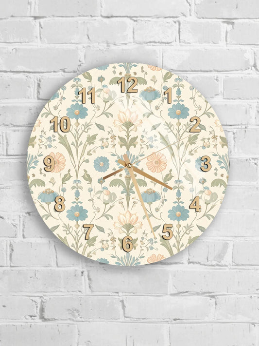 A round wall clock with a floral pattern and numbers on a white brick wall.