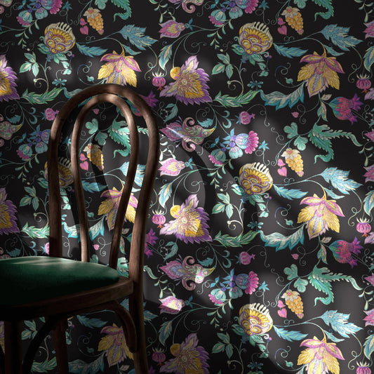 a dark-colored floral wallpaper with a wooden chair positioned in front of it.