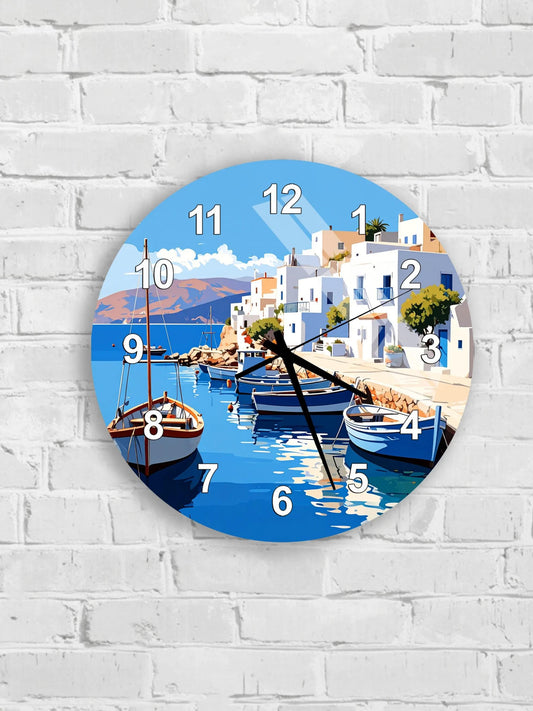 A round wall clock with a blue background depicting a picturesque coastal town with boats on the water.