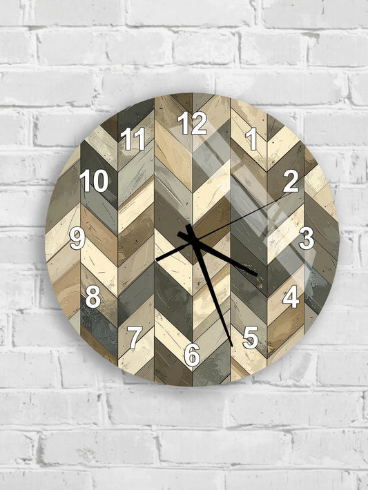 A wall clock with a chevron pattern design, mounted on a white brick wall.