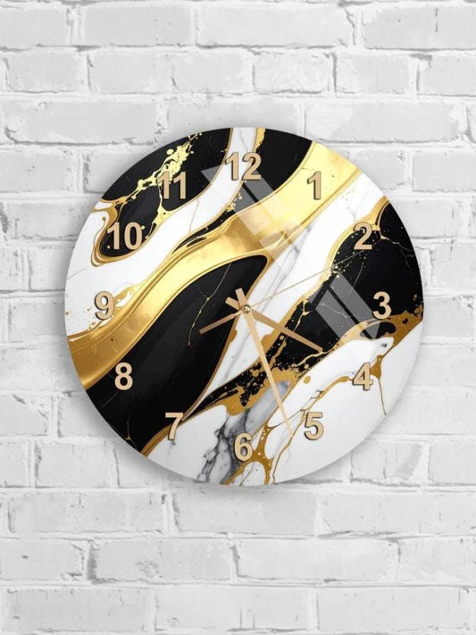 A wall clock with a black and white marble design and gold accents, mounted on a white brick wall.