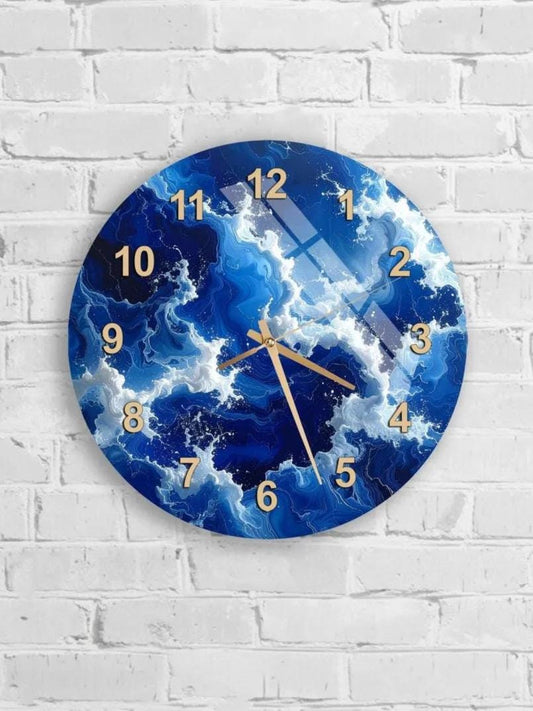 A wall clock with a blue and white ocean wave design, mounted on a white brick wall.