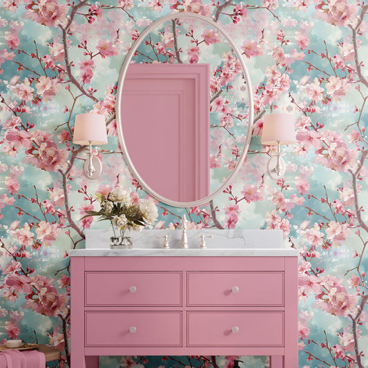 a bathroom with a pink vanity and a large mirror above it, set against a wall with a floral wallpaper.