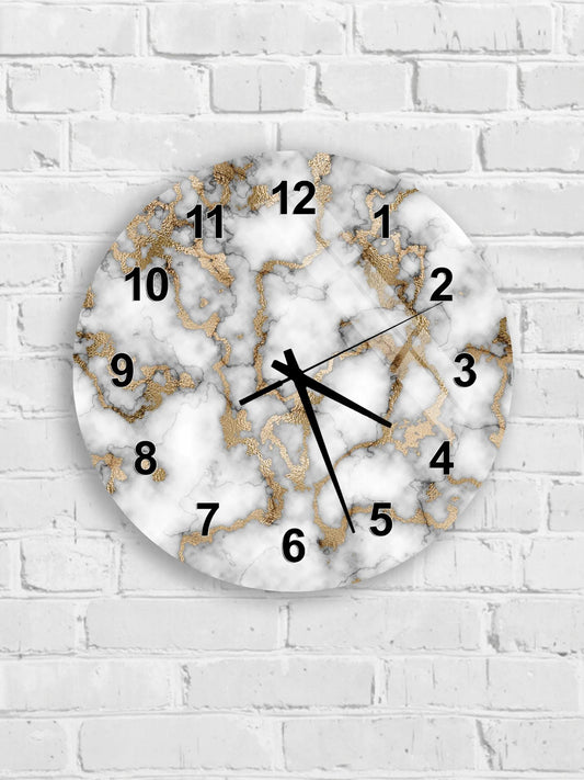 A round wall clock with a marble-like design and gold accents, mounted on a white brick wall.