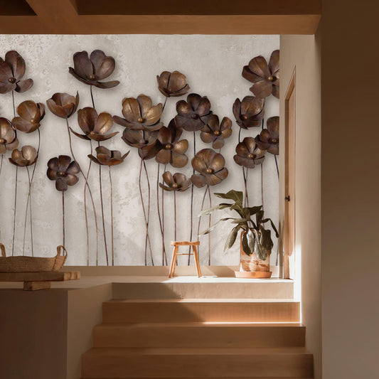 a wall adorned with a collection of large, intricately designed metal flowers, creating a striking visual display. The wall is set against a light-colored background, which highlights the metallic sheen of the flowers. In the foreground, there is a wooden staircase leading up to a higher level, and a small potted plant is placed on the steps. The overall composition of the image is visually appealing and draws attention to the artistic elements of the wall design.