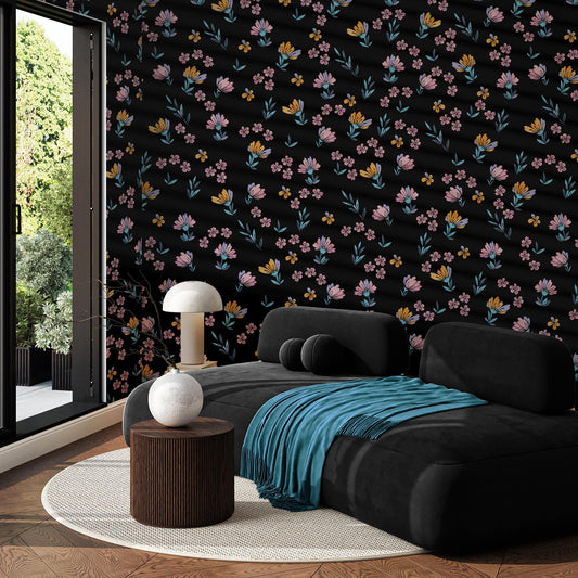 a modern living room with a black sofa, a round wooden table, and a white lamp. The walls are adorned with a floral pattern in shades of pink, blue, and yellow, creating a vibrant and lively atmosphere. The room is well-lit, with natural light coming in through a large window, and the overall design is stylish and contemporary.