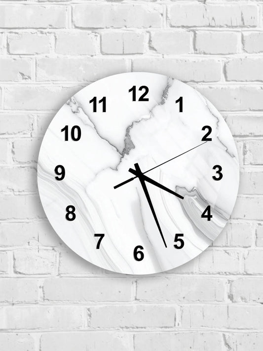 A white marble wall clock with black numbers and hands is mounted on a white brick wall.