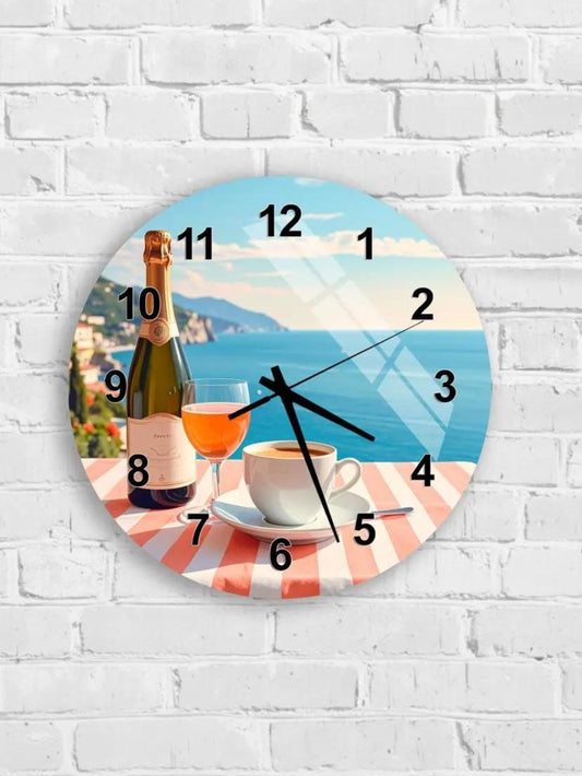A wall clock with a scenic ocean view and a bottle of wine and a glass of wine on a table, set against a white brick wall.