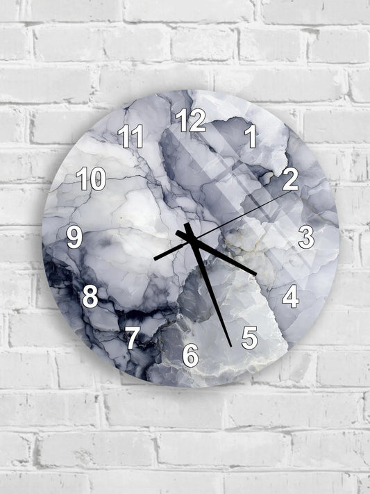 A wall clock with a marble-like design on its face, mounted on a white brick wall.