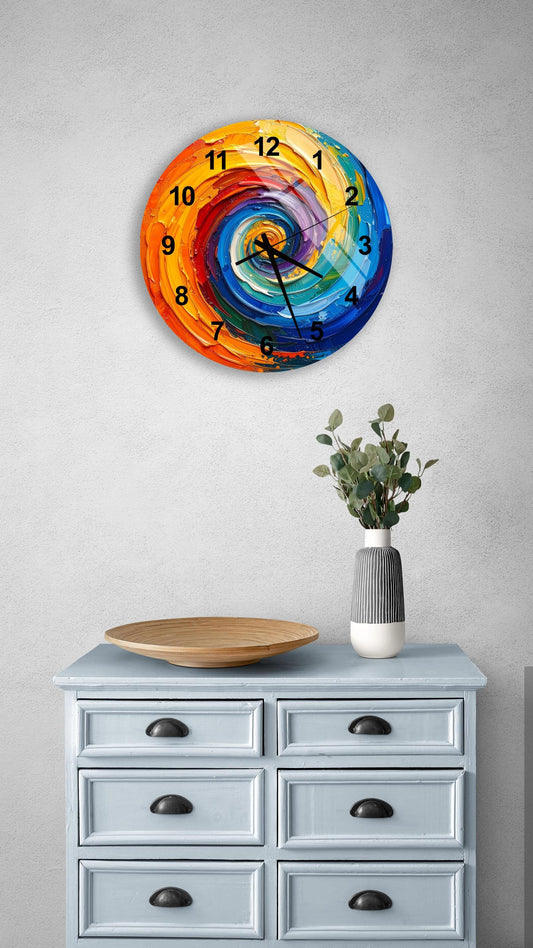 a colorful, abstract clock with a spiral design on a wall above a light blue dresser with six drawers. The dresser also has a vase of greenery and a wooden tray on top.