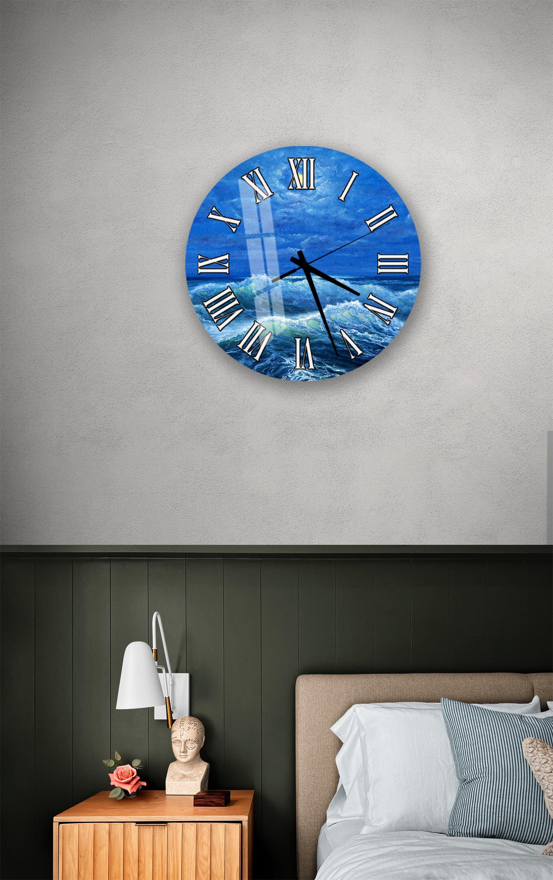 a bedroom setting with a large wall clock displaying a blue ocean scene, a wooden nightstand with a lamp, and a bed with white pillows.