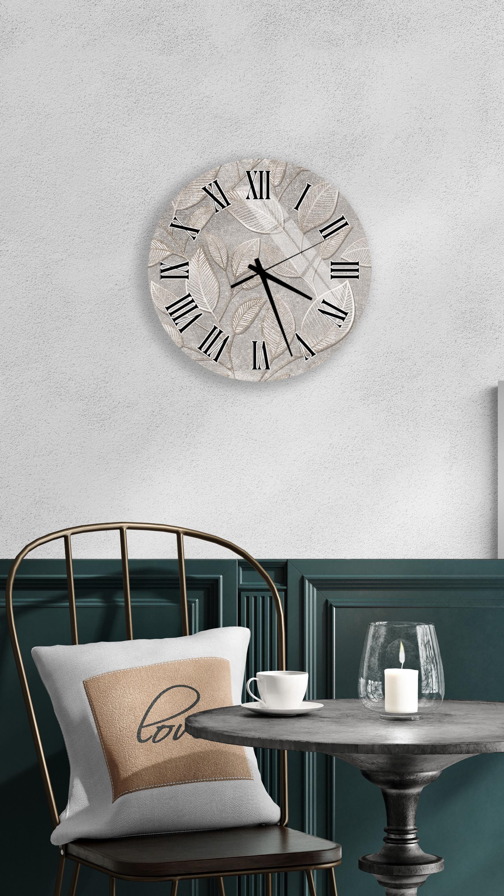 a modern interior design with a round wall clock, a black metal chair, a white table with a candle, and a beige pillow with the word "love" on it.