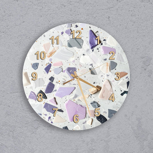 A wall clock with a unique design made of colorful, irregularly shaped pieces, creating a visually striking and artistic appearance.