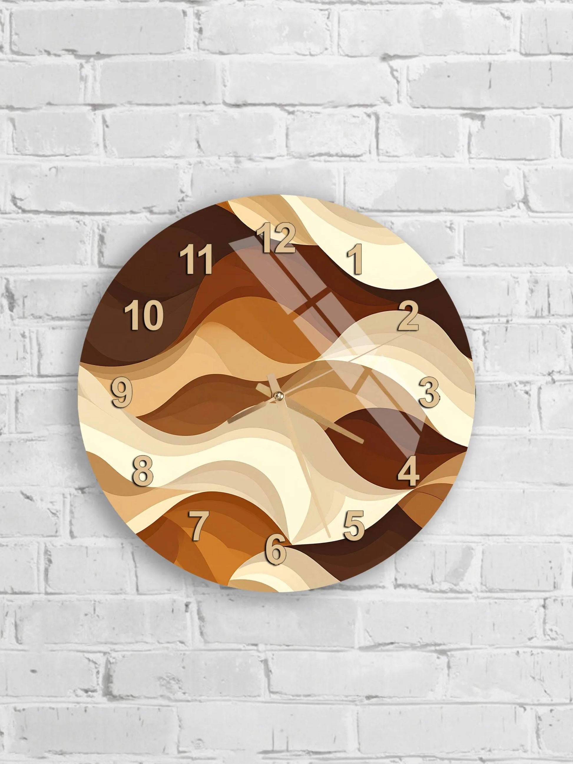 A round wall clock with a brown and beige abstract design, mounted on a white brick wall.