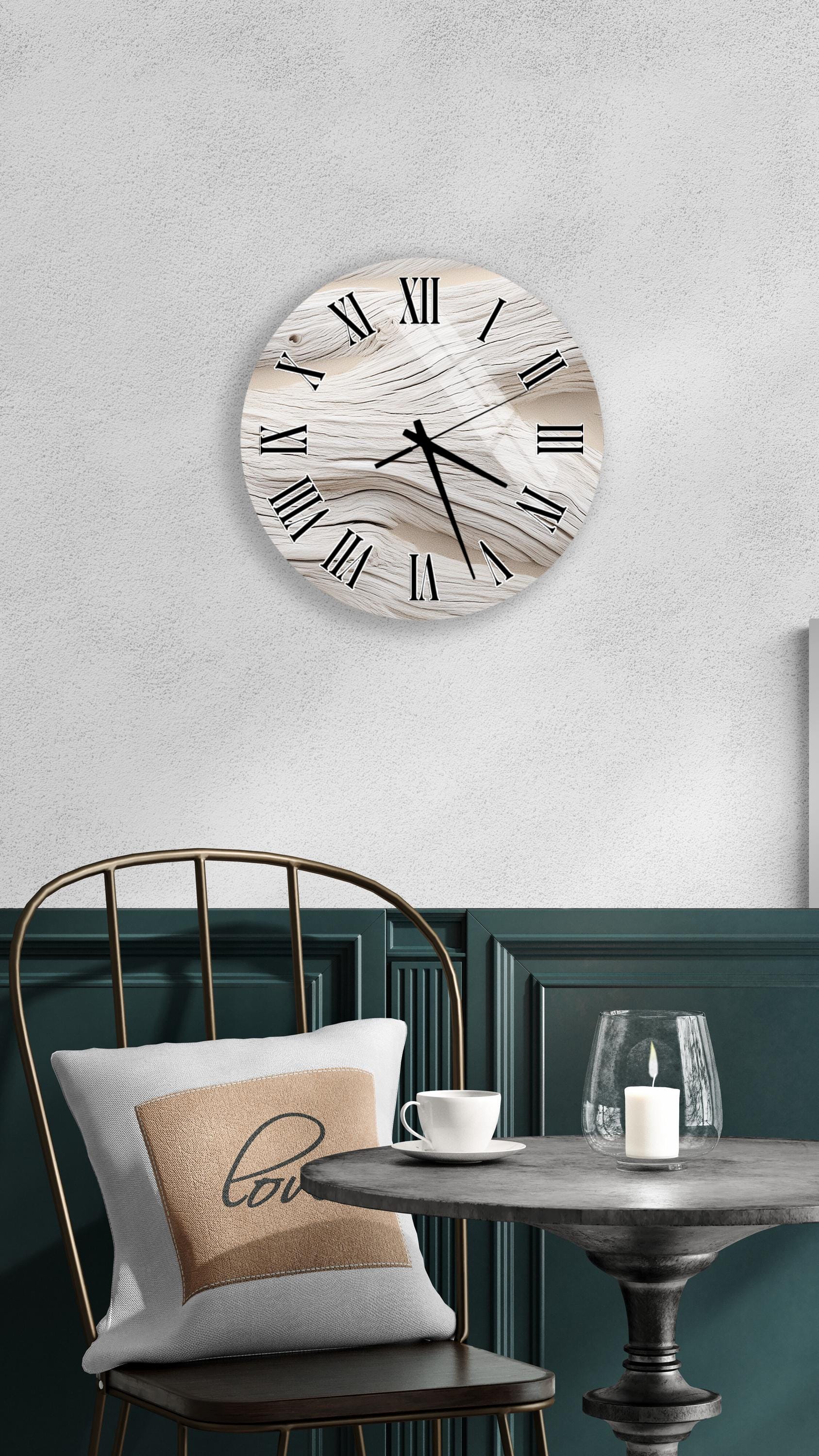 a modern interior design with a round wall clock, a black metal chair, a white table with a candle, and a beige pillow with the word "love" on it.