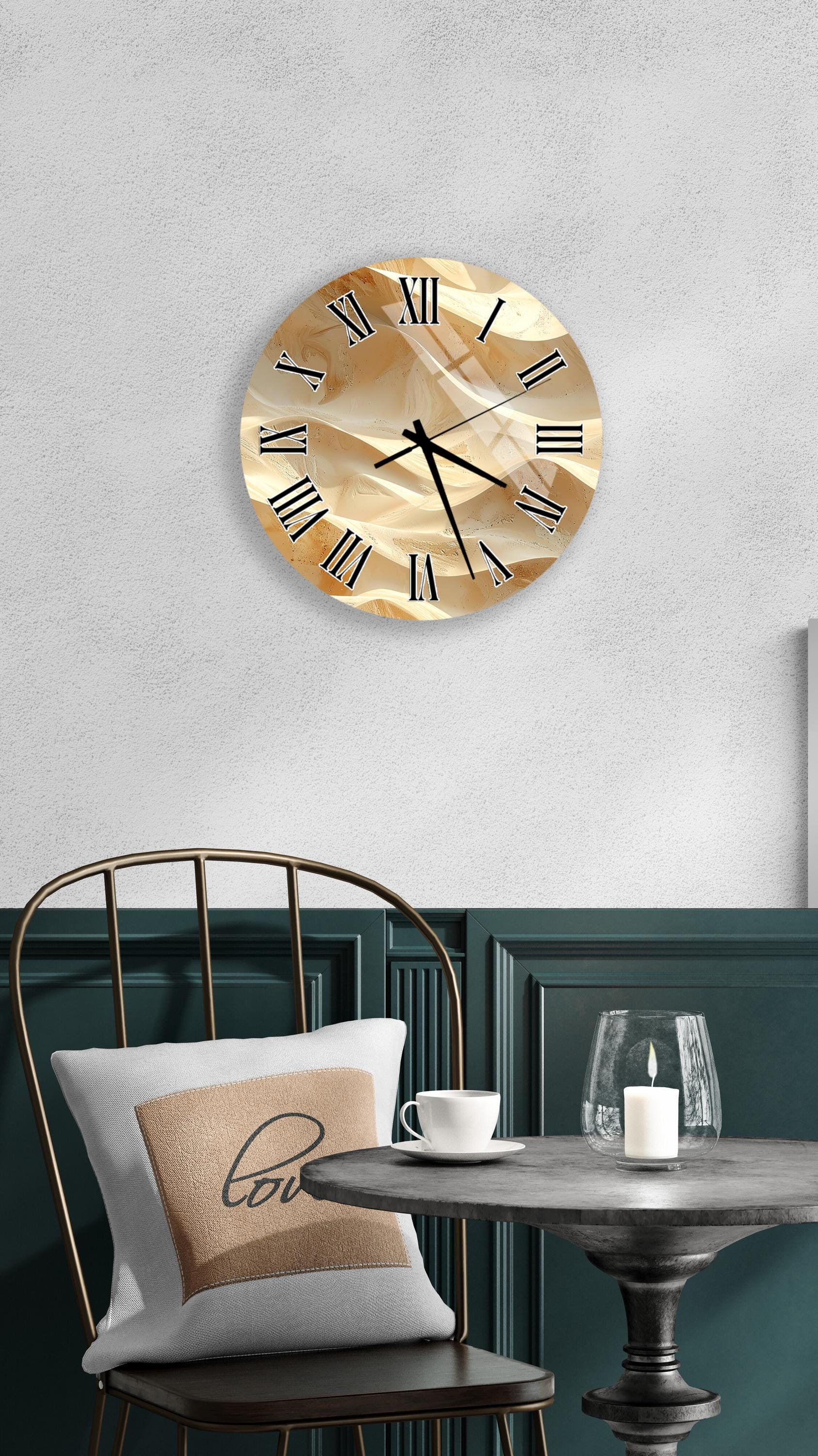 a wall clock with a gold-colored face, a white table with a candle and a glass, and a chair with a pillow on it.