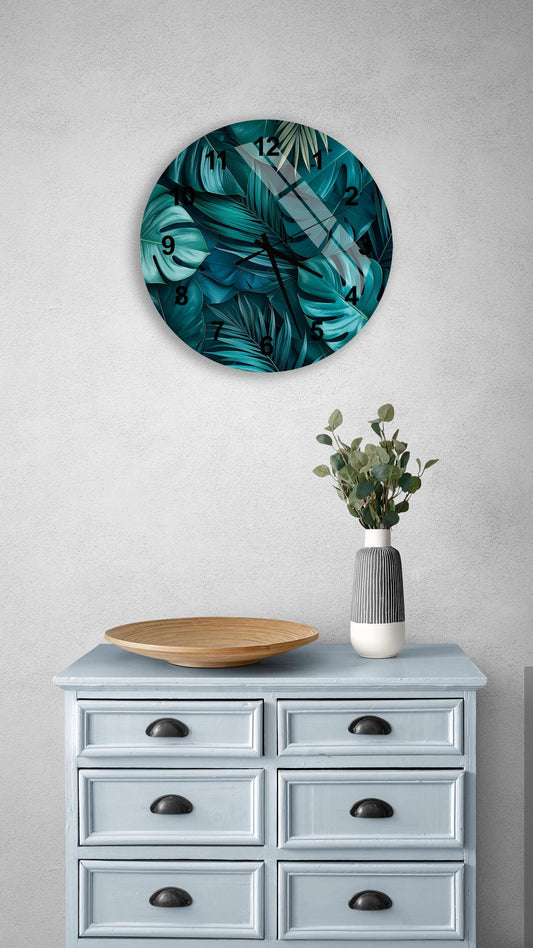 a round clock with a tropical leaf design on a light blue dresser with six drawers. The clock is mounted on the wall above the dresser, and there is a vase with greenery on the dresser.