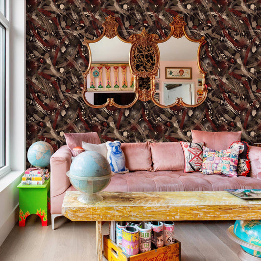 a cozy living room with a pink sofa adorned with colorful pillows, a wooden coffee table, and a large mirror on the wall. The room also features a bookshelf filled with various items, and a globe on a side table.