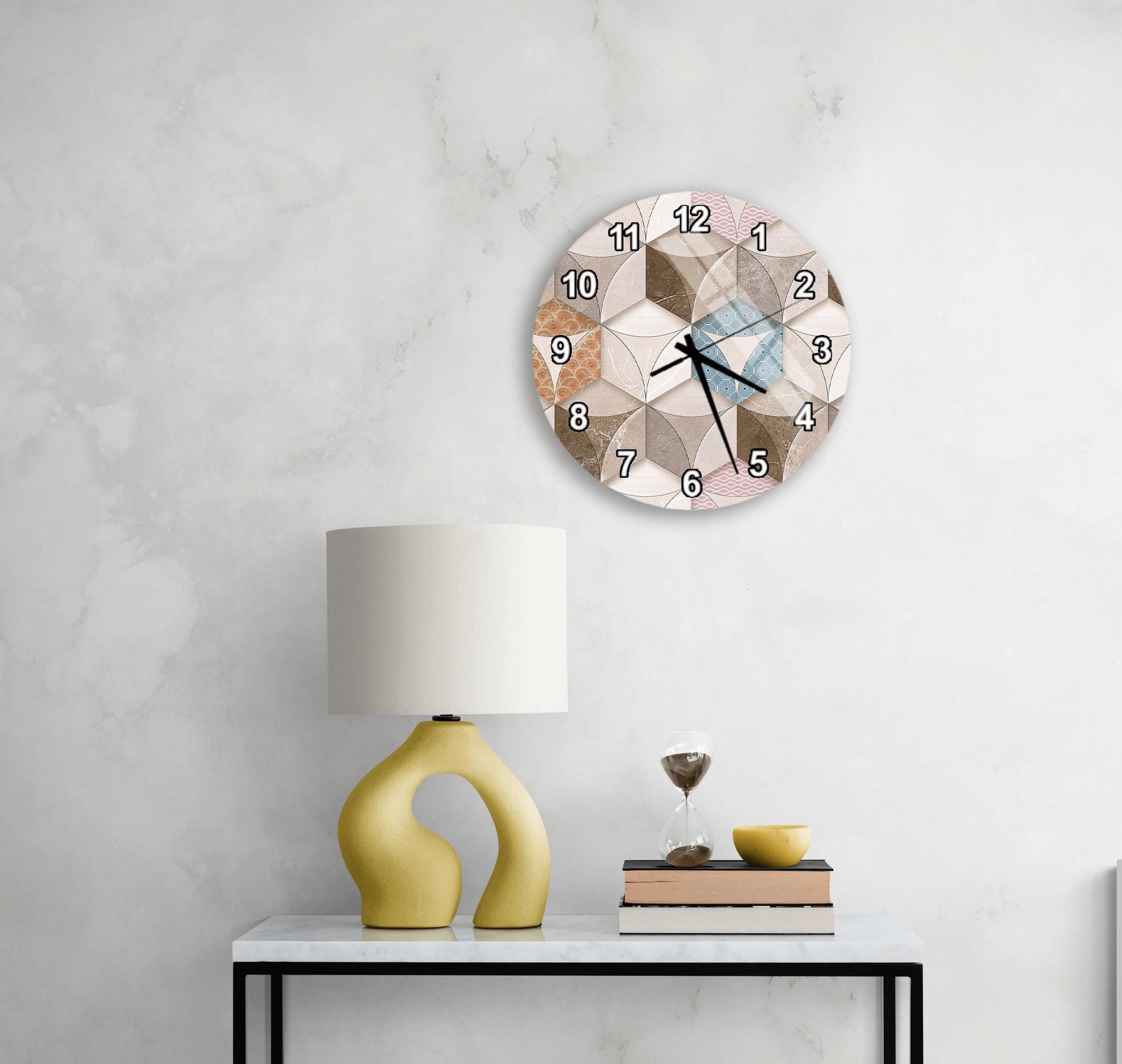 a modern, minimalist living space with a white wall, a round clock with a geometric design, a yellow lamp with a unique, curved base, and a small table with a book and a glass of water.
