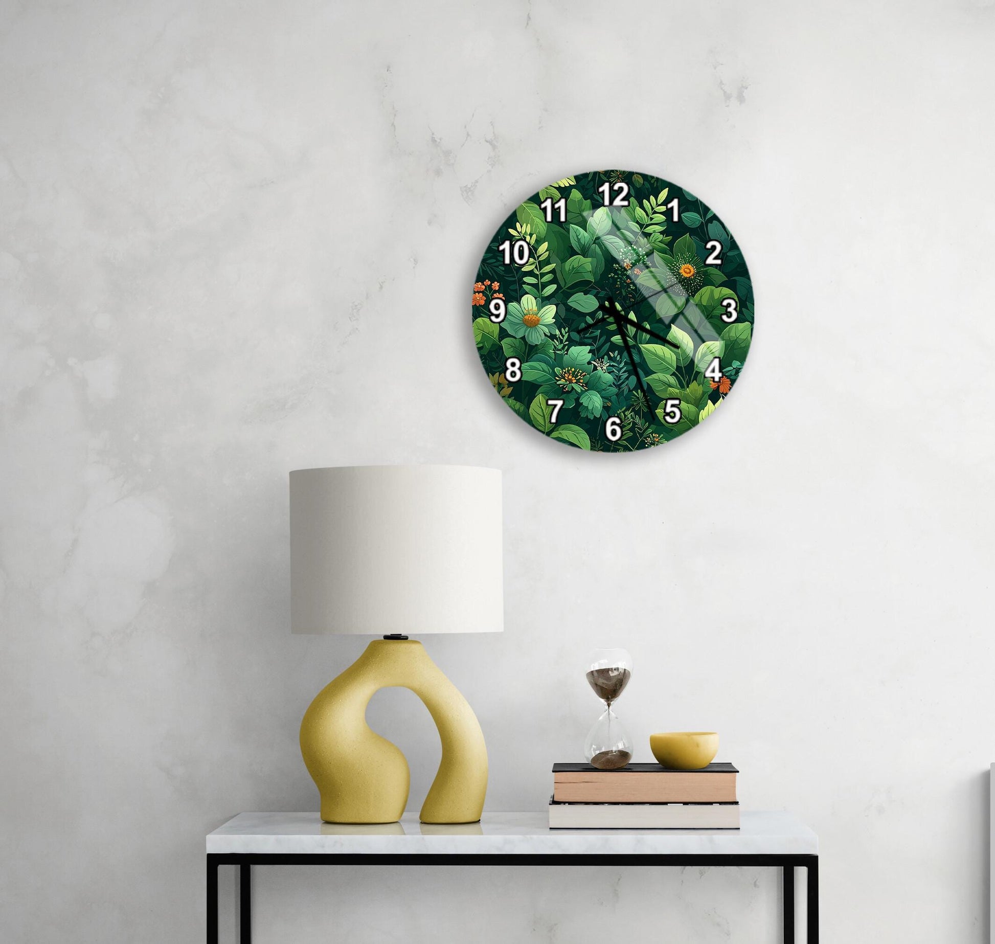 a white wall with a round clock displaying a green floral pattern, a yellow lamp with a unique curved base, a stack of books, and a glass of wine on a white table.