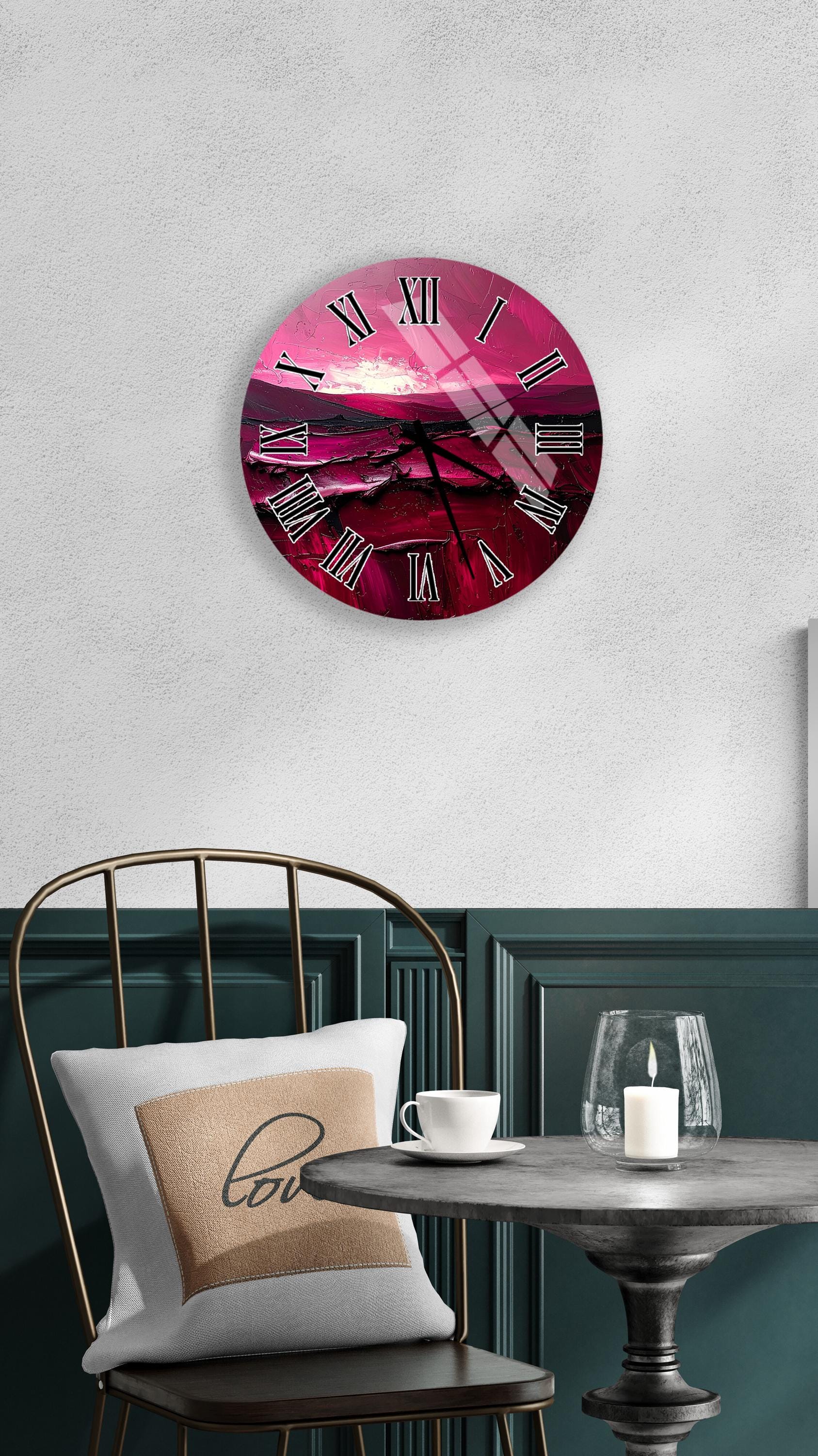 a round wall clock with a pink and purple color scheme, hanging on a white wall above a dining table with a white tablecloth.