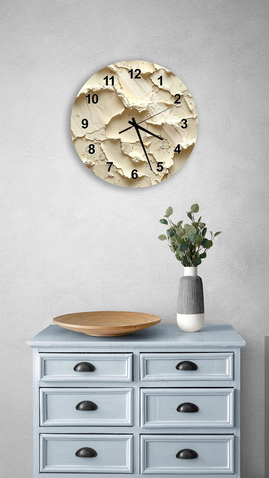 a wall clock with a unique, textured design, mounted on a wall above a light blue dresser with six drawers. The dresser also has a vase with greenery on it, and there is a wooden plate on the dresser.