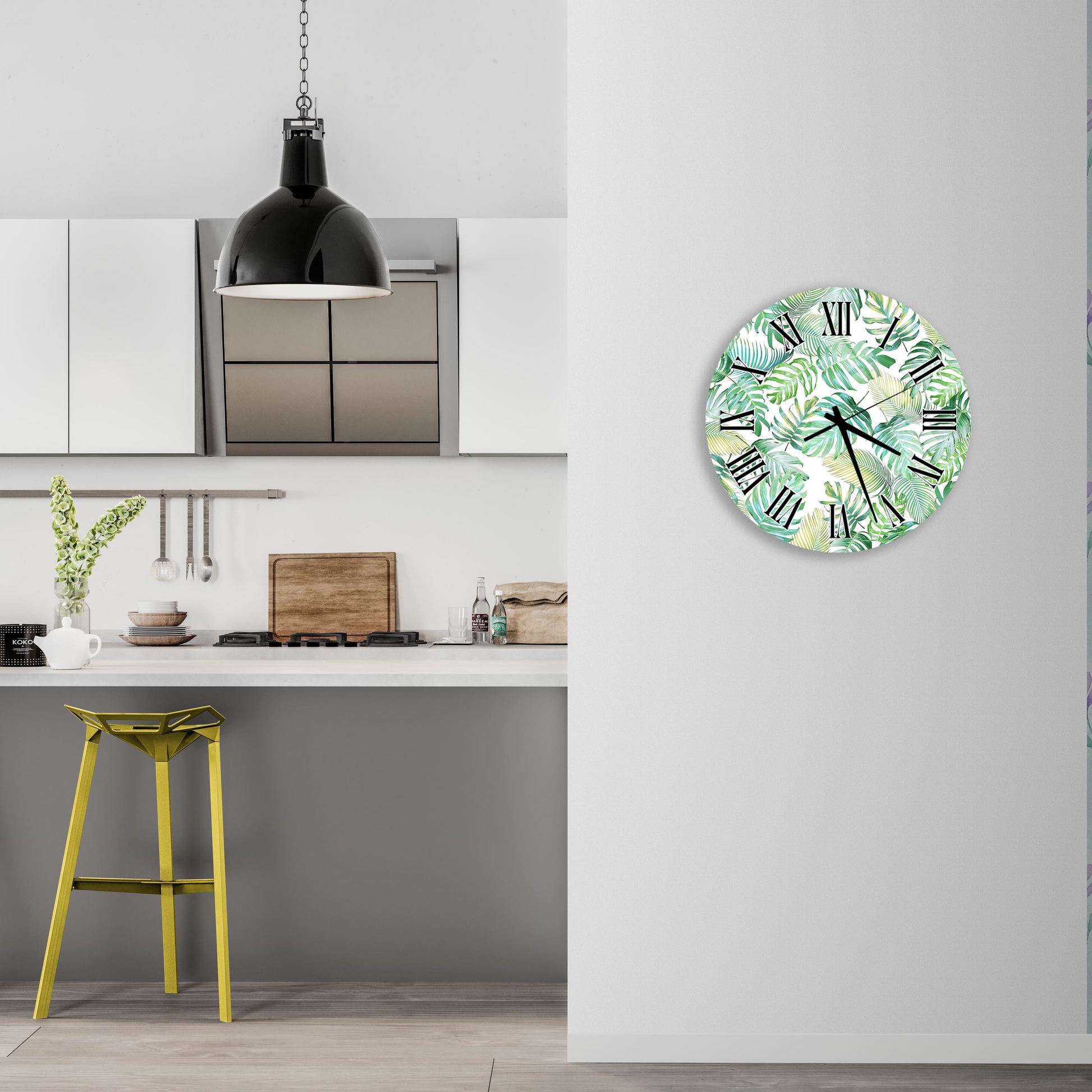 a kitchen with a yellow stool, a hanging light fixture, and a round wall clock with a tropical leaf pattern.