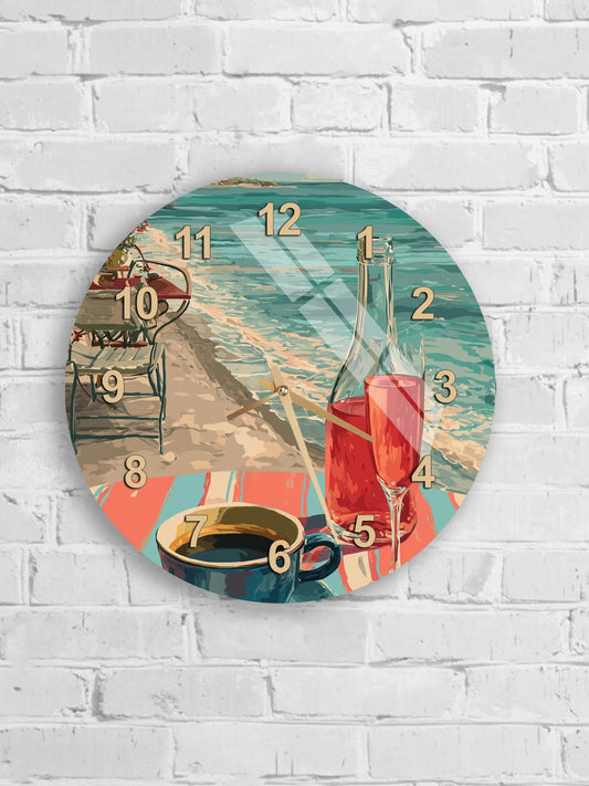A round wall clock with a beach scene depicted on its face, including a beach chair, a glass of wine, and a cup of coffee.