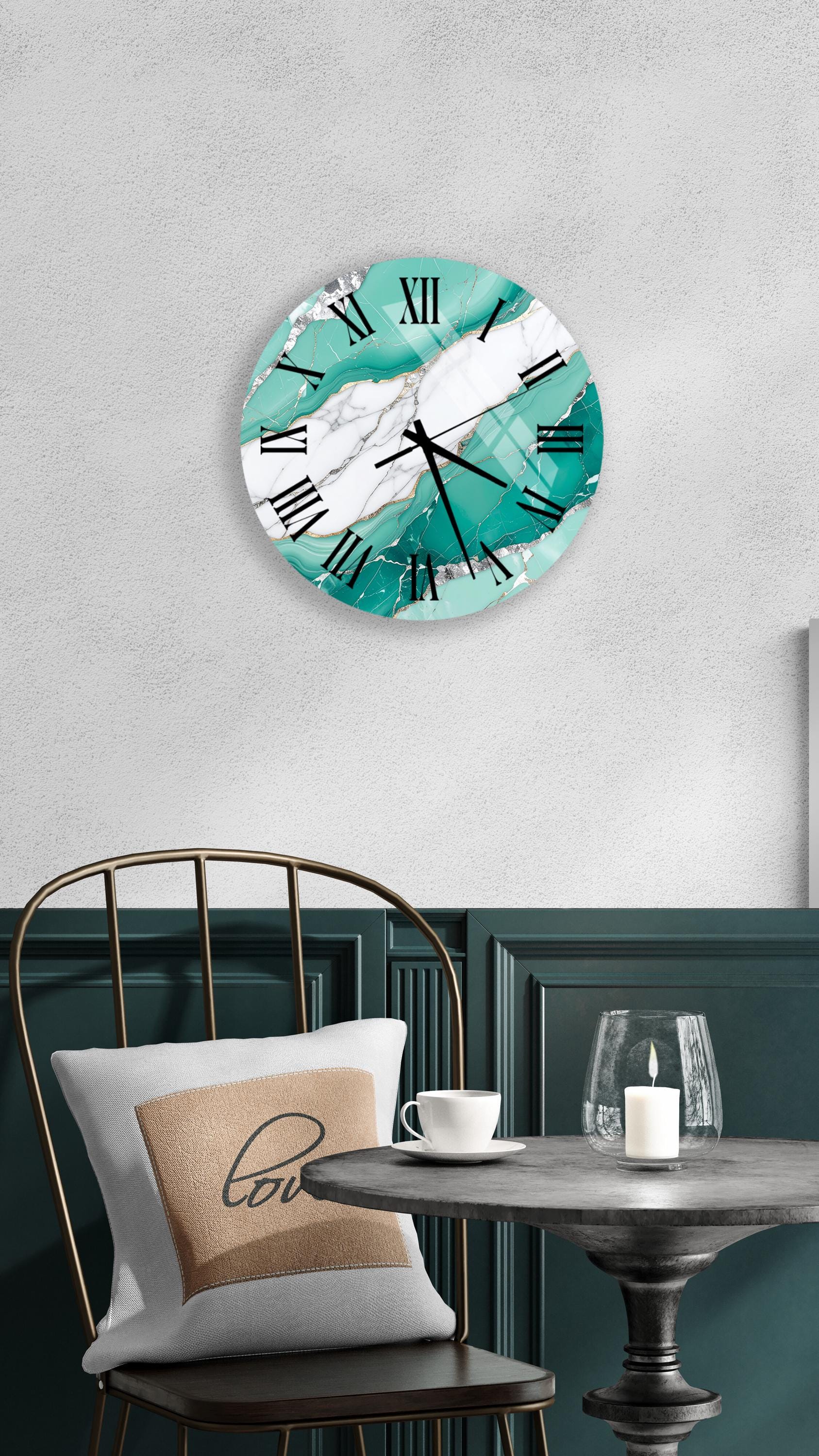 a modern and stylish interior design with a teal-colored wall clock, a white table with a candle, and a black metal chair.