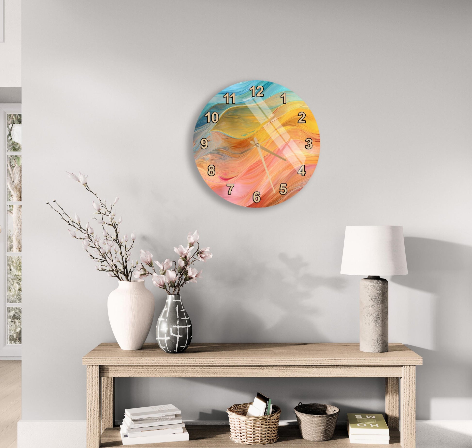 a wall clock with a colorful abstract design, a wooden table with a lamp, a vase with flowers, and some books on a shelf.