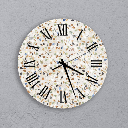A round wall clock with a mosaic pattern on its face, displaying the time as approximately 10:10.
