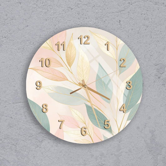 A wall clock with a leafy, nature-inspired design on its face.
