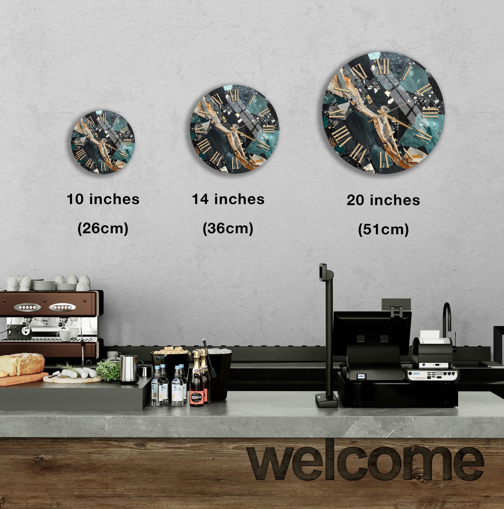 a wall with three clock designs of different sizes, and there is a counter with various items on it, such as bottles and a sandwich.