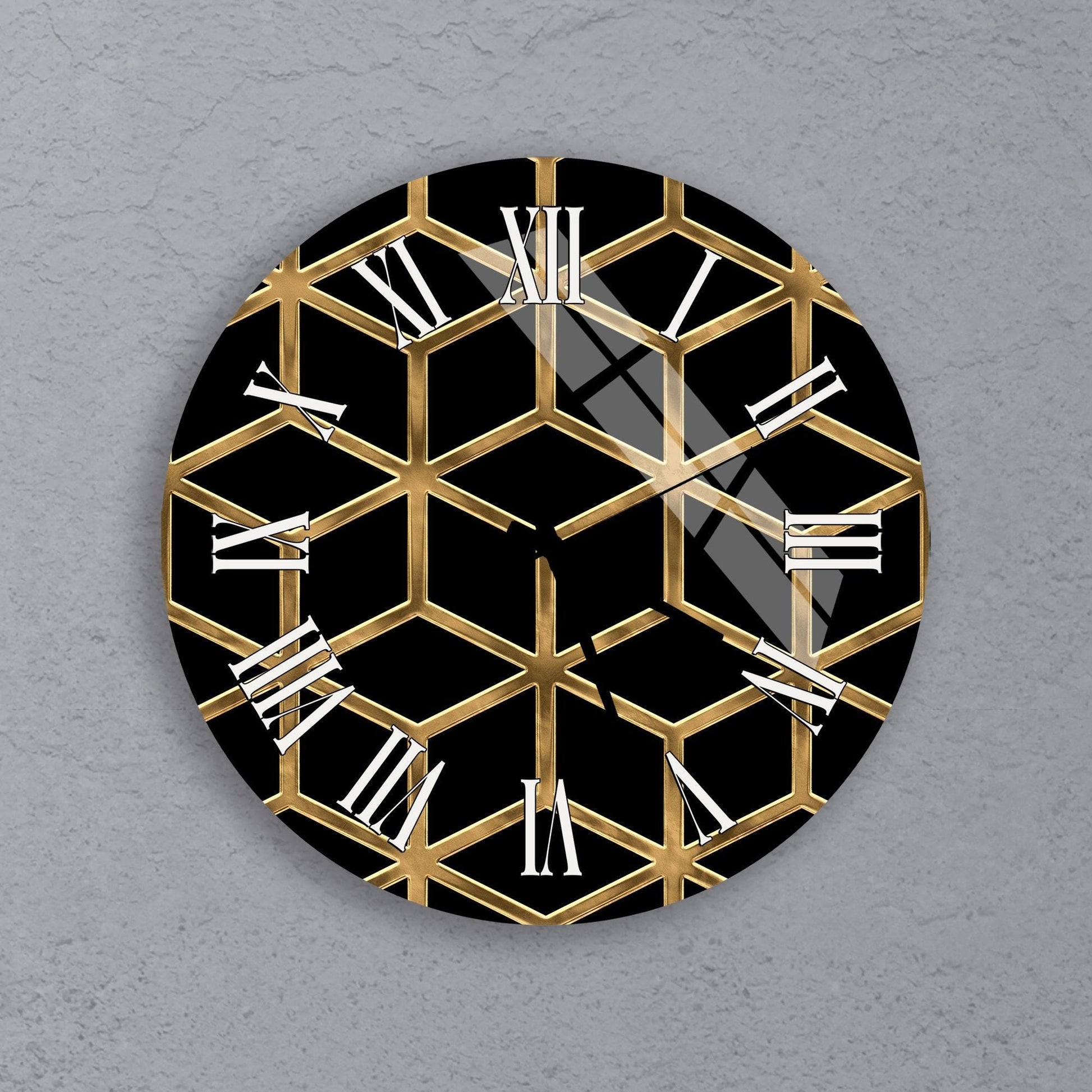 a clock with a black and gold geometric design on a gray background.