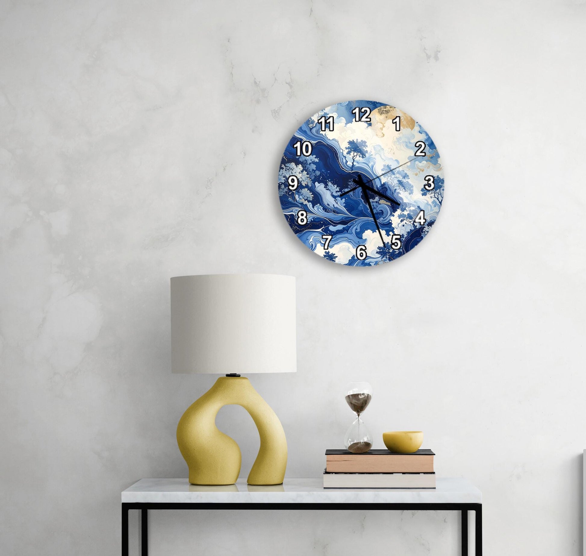 a modern living room with a white marble wall, a round clock with a blue and white ocean design, a yellow lamp on a white table, and a stack of books.