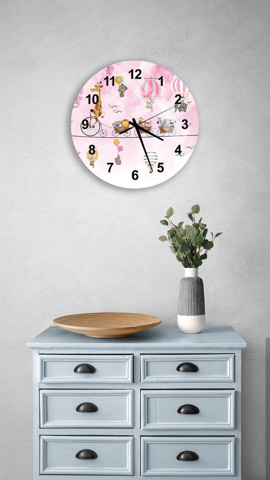 a wall clock with a pink and white design, mounted on a wall above a light blue dresser with six drawers. The dresser also has a vase with greenery and a wooden tray on top.