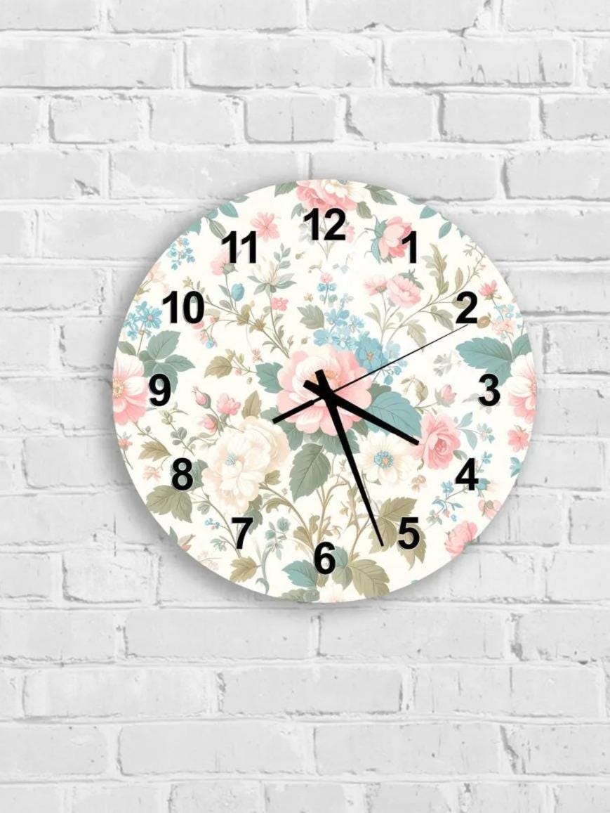 A wall clock with a floral pattern on the face, mounted on a white brick wall.