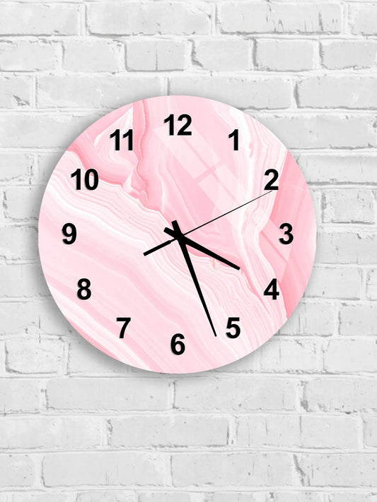 A pink marble-like clock with black numbers and hands is mounted on a white brick wall.