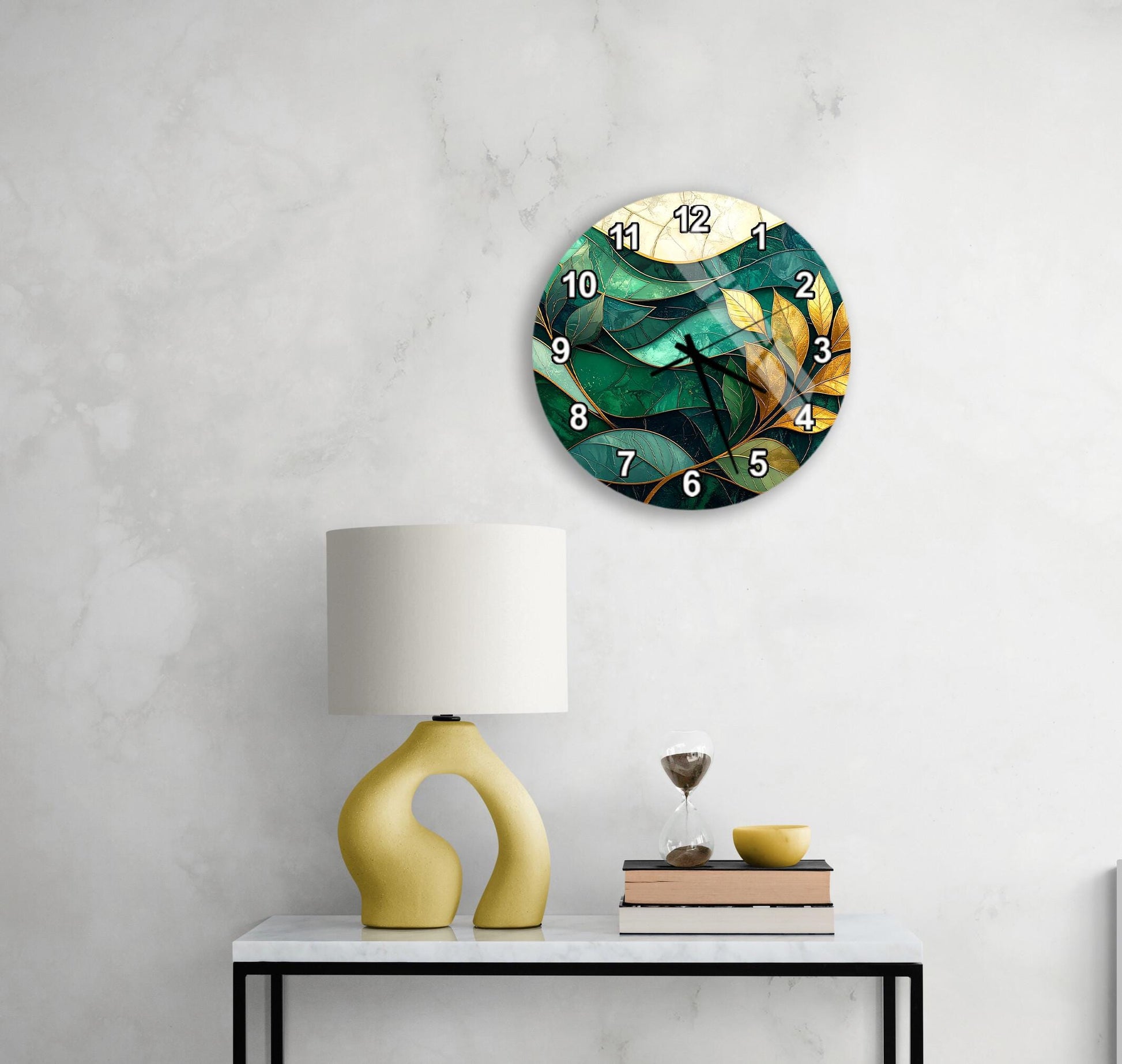 a modern, abstract clock with a green and yellow design, mounted on a wall above a white table with a yellow lamp and a stack of books.