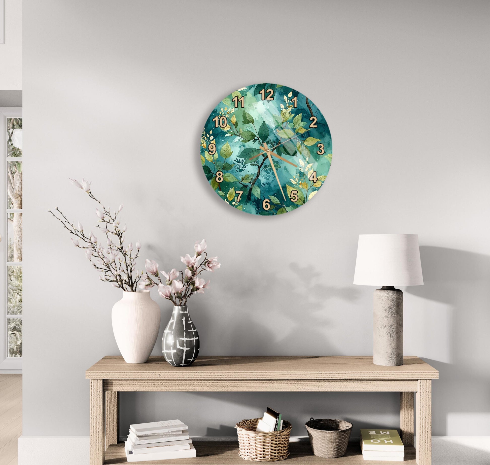 a wall clock with a green and white floral design, a wooden table with a lamp, a vase with pink flowers, and a stack of books.