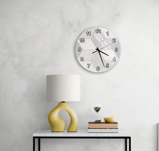 a modern living room with a white wall, a round clock with a geometric design, a yellow lamp with a unique curved base, and a small table with a book and a glass of wine.