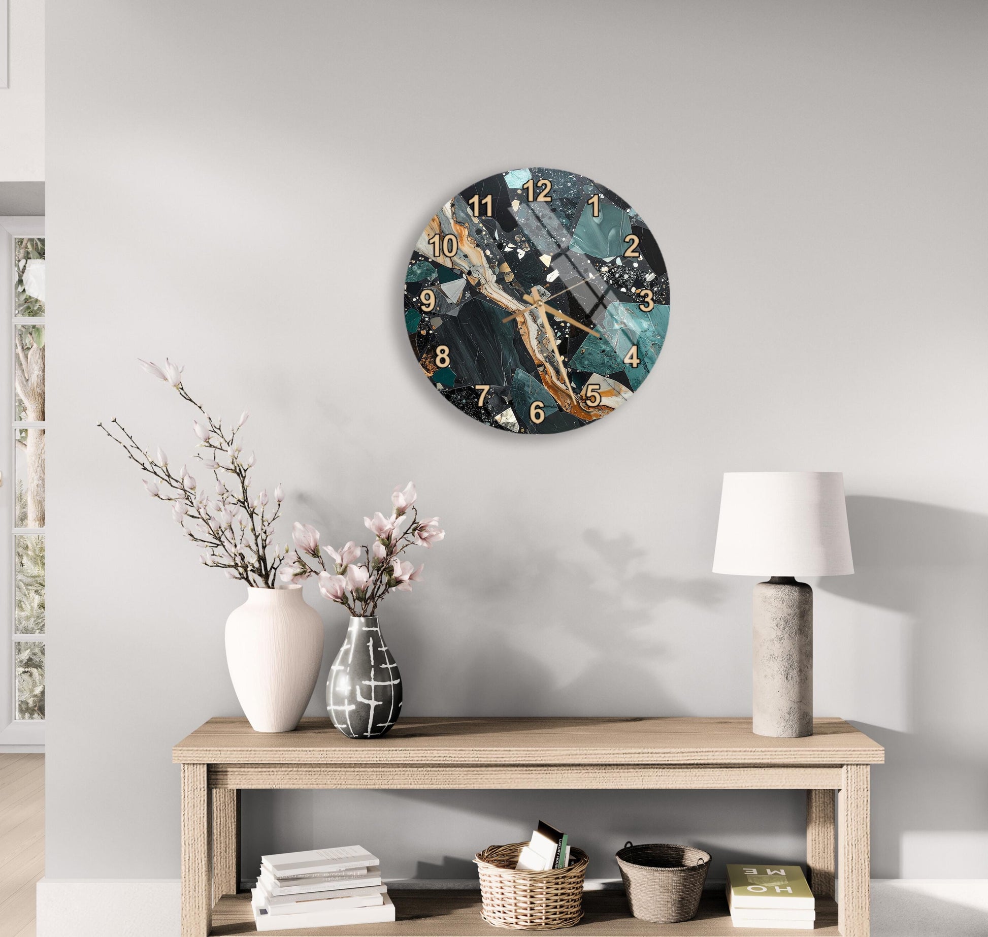 a modern living room with a wooden console table, a round wall clock with a marble and teal design, a white vase with pink flowers, and a lamp on the table.