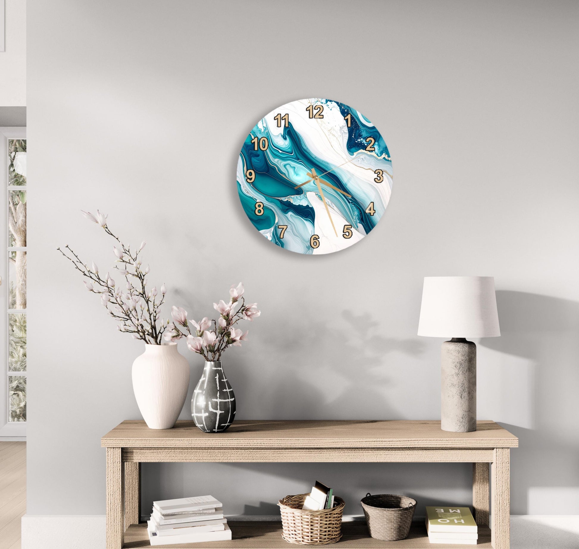 a modern and minimalist living room with a round wall clock displaying a blue and white marble design, a wooden table with a lamp, a vase with pink flowers, and a stack of books.