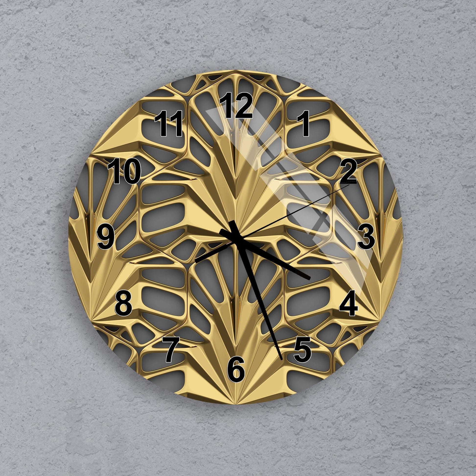 A gold-colored wall clock with a unique, geometric design and black hands indicating the time.