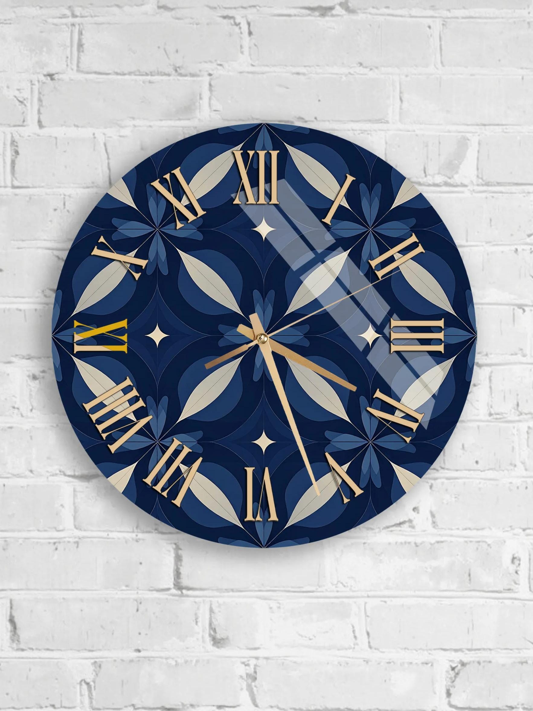A round wall clock with a blue and gold design, mounted on a white brick wall.