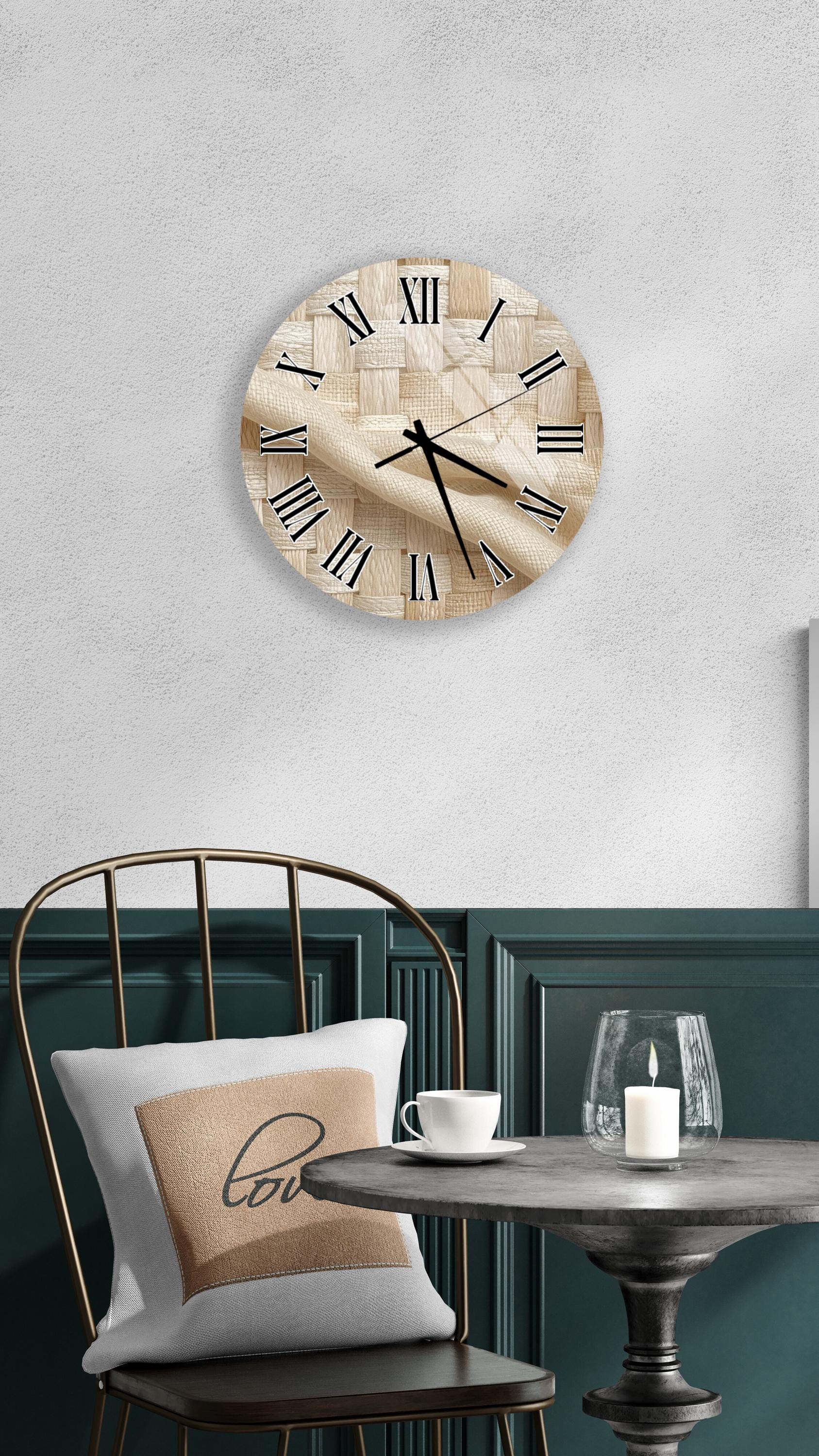 a round wooden clock with Roman numerals mounted on a wall above a table with a white tablecloth and a candle.