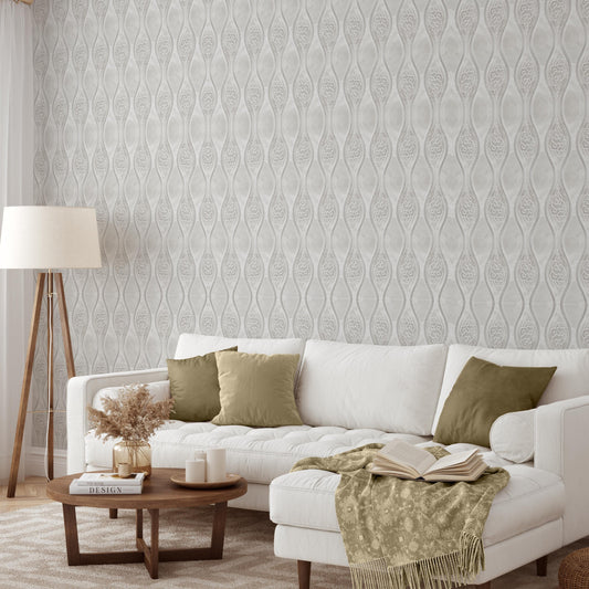 a cozy living room with a white sofa adorned with green throw pillows, a wooden coffee table, and a lamp on a side table. The room is decorated with a patterned wallpaper and a rug, creating a warm and inviting atmosphere.