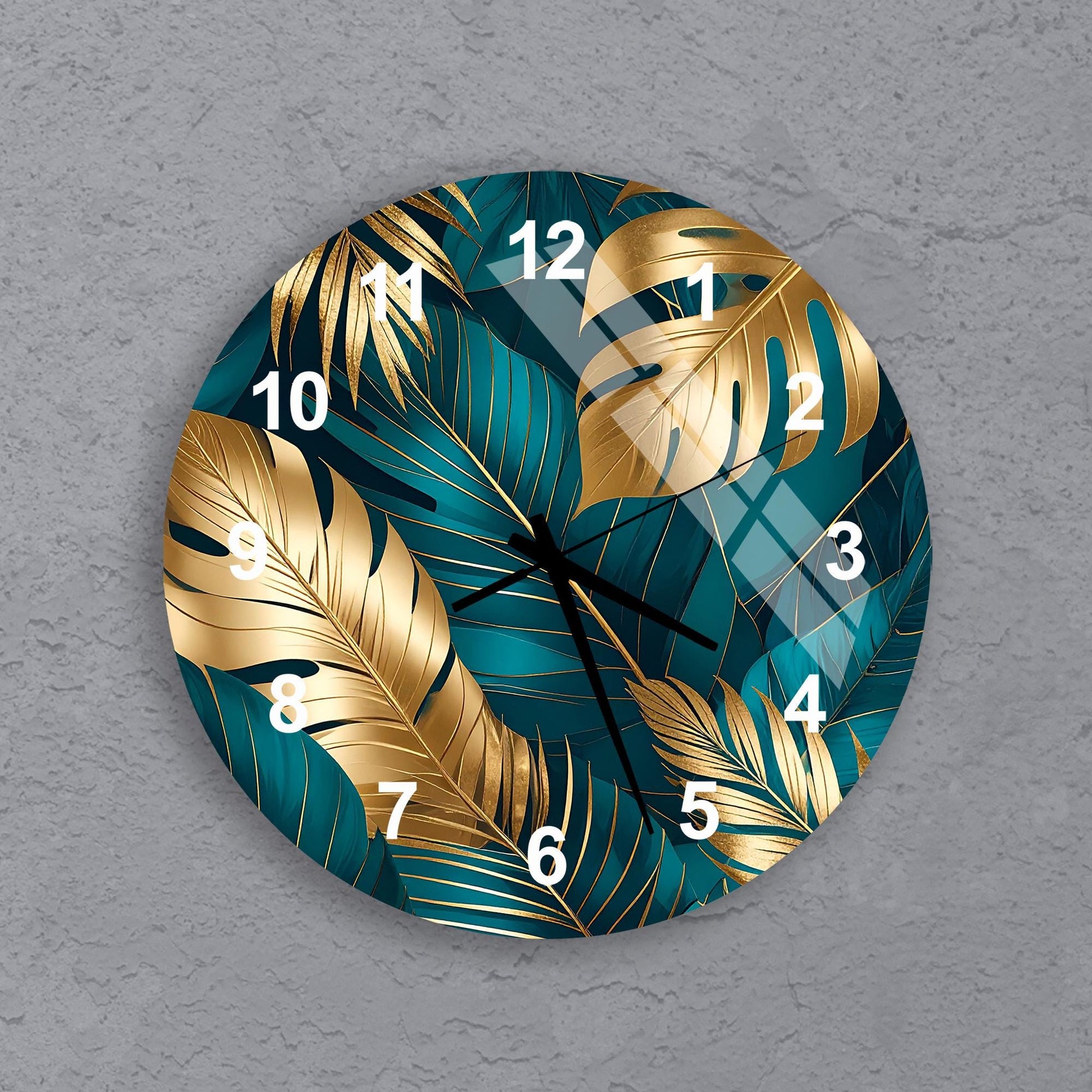 A wall clock with a tropical leaf design in shades of blue and gold.