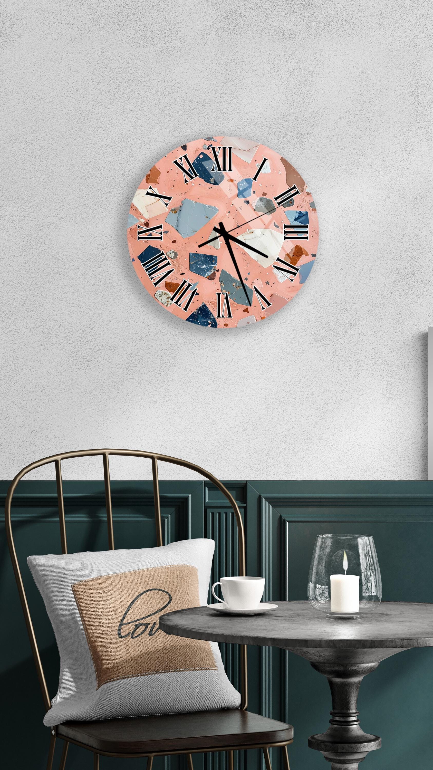 a modern and stylish interior design with a round clock featuring a pink and blue color scheme, a white table with a candle, and a black chair with a white pillow.
